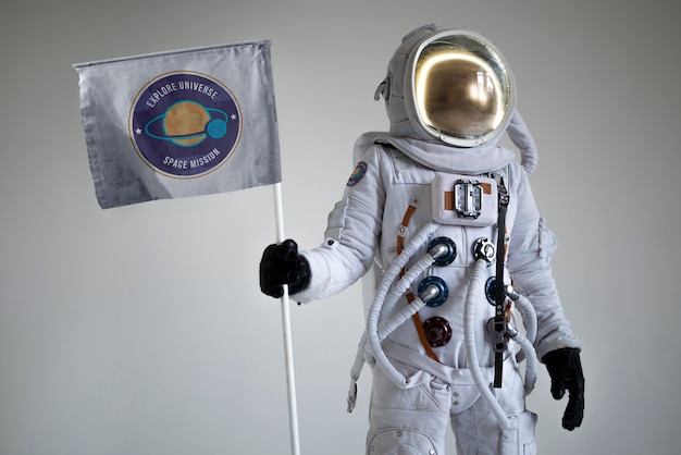 Astronauta masculino totalmente equipado sosteniendo una bandera