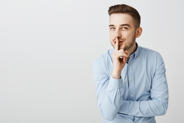 Astuto hombre de negocios divertido callar con sonrisa, preparar sorpresa