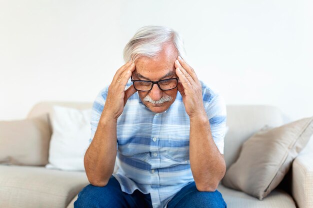 Ataque de la migraña monstruosa Hombre mayor jubilado infeliz sosteniendo su cabeza con expresión de dolor Cara del hombre mayor que sufre de dolor de cabeza