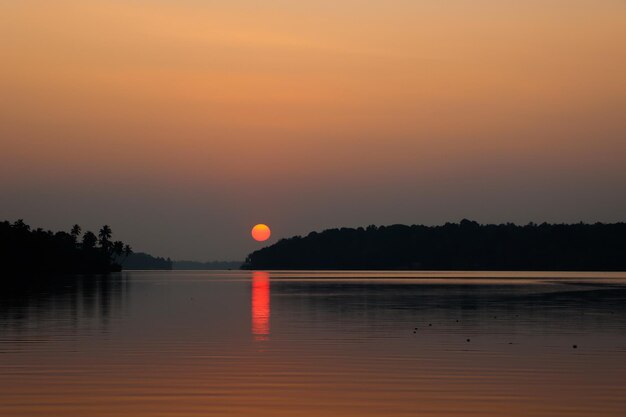 Atardecer oscuro en el lago Kollam Ashtamudi