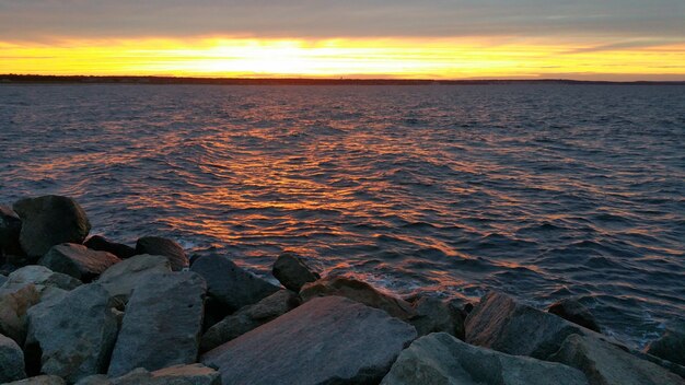 Atardecer en una playa con rocas