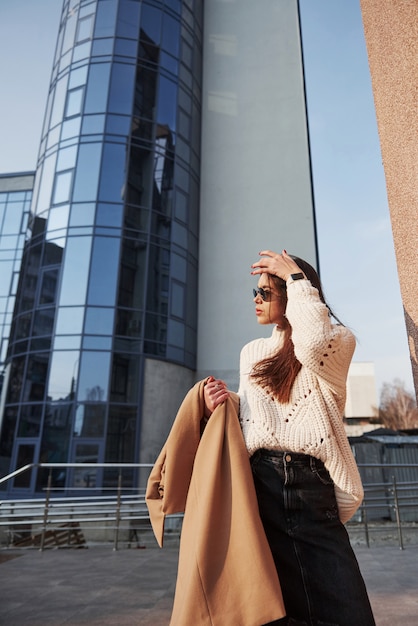 Atardecer pronto. Hermosa joven en ropa de abrigo tiene caminar en la ciudad en su tiempo de los fines de semana