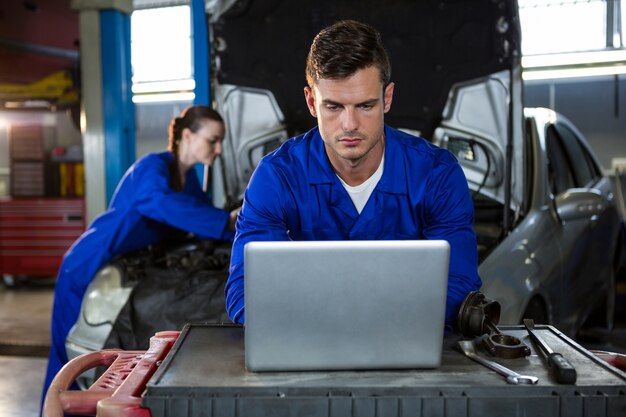 Atento de trabajo mecánico en la computadora portátil
