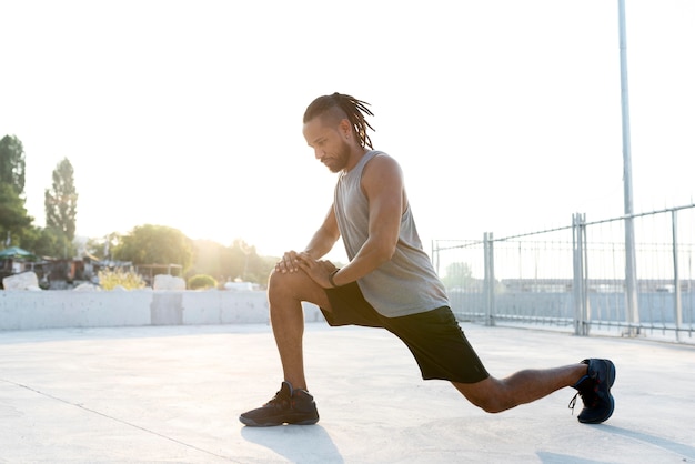 Atleta afroamericano que se extiende al aire libre