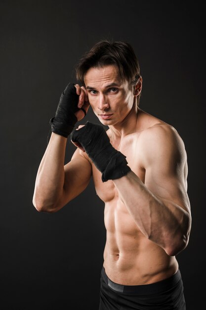 Atleta sin camisa posando en guantes de boxeo