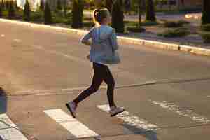 Foto gratuita atleta corredor corriendo en carretera. mujer fitness trotar entrenamiento concepto de bienestar.