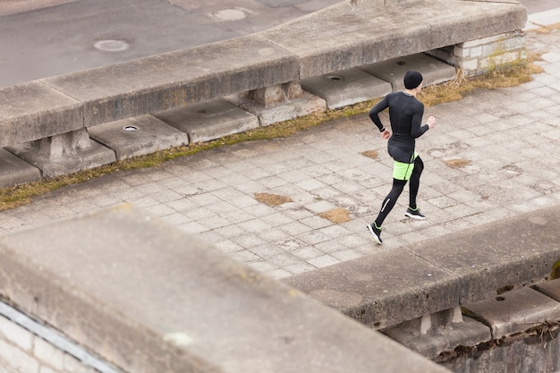 Atleta corriendo en ciudad lluviosa