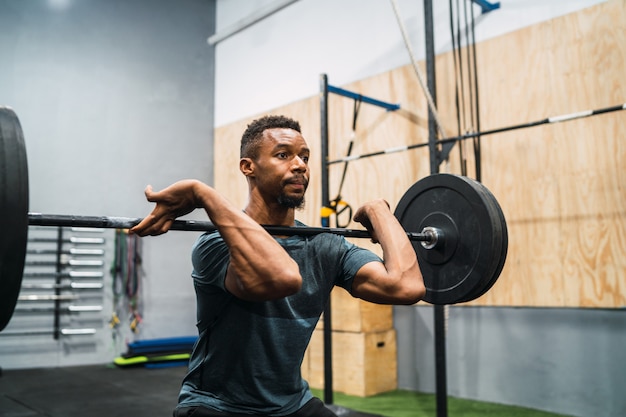 Atleta de Crossfit haciendo ejercicio con una barra.