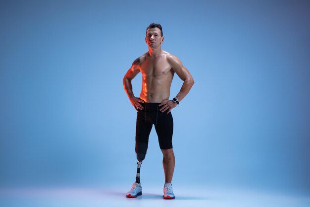 Atleta con discapacidad o amputado aislado sobre fondo azul studio