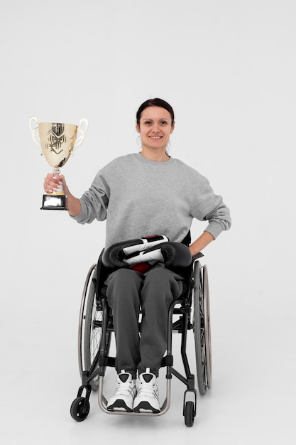 Atleta femenina discapacitada sosteniendo una copa de oro