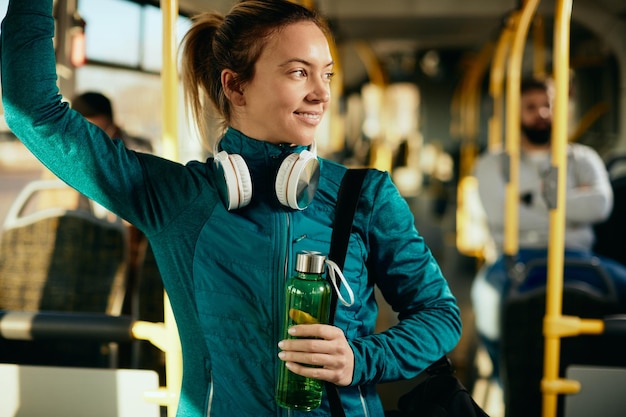 Atleta femenina feliz viajando en transporte público