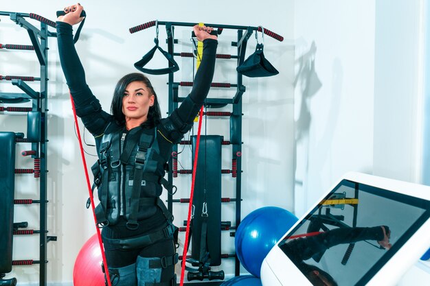 La atleta femenina haciendo ejercicio en un gimnasio ems