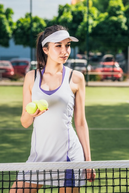 Atleta femenina sosteniendo pelotas de tenis en la mano