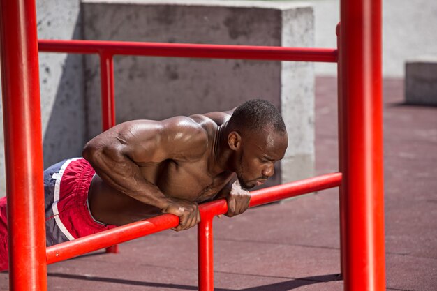 El atleta en forma haciendo ejercicios en el estadio.