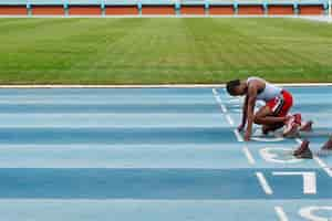 Foto gratuita atleta en la línea de salida en el estadio