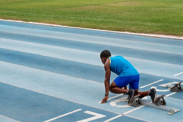 Foto gratuita atleta en la línea de salida en el estadio