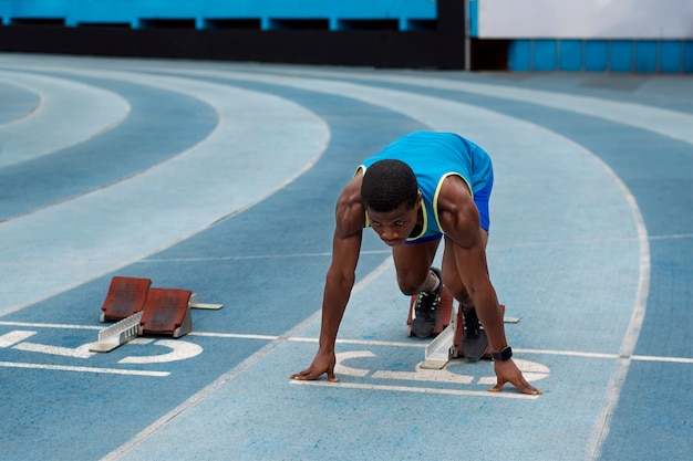 Foto gratuita atleta en la línea de salida en el estadio