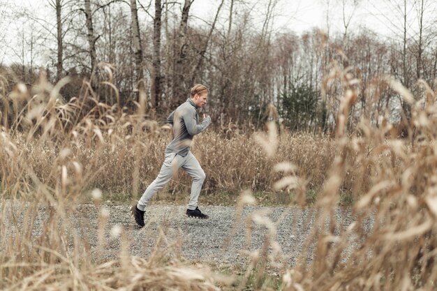 Atleta masculino de fitness joven corriendo en la granja