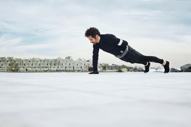 Atleta Masculino haciendo flexiones fuera