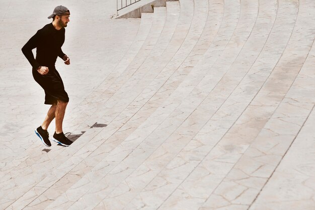 Atleta masculino joven que ejercita en las escaleras