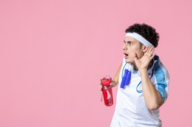 Atleta masculino de vista frontal en ropa deportiva con botella de agua