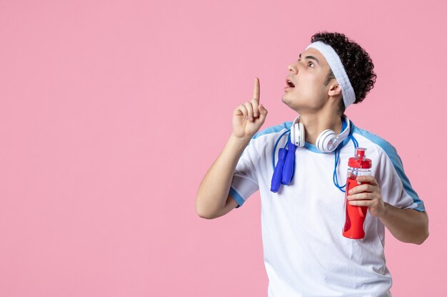 Atleta masculino de vista frontal en ropa deportiva con botella de agua