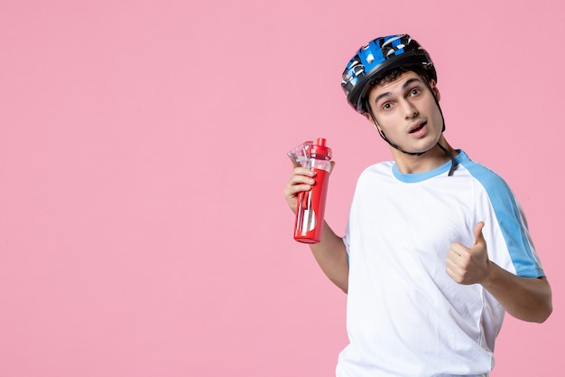 Atleta masculino de vista frontal en ropa deportiva con casco y botella de agua