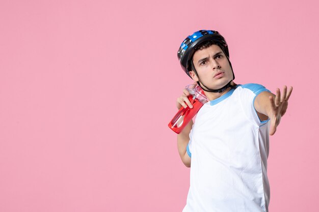 Atleta masculino de vista frontal en ropa deportiva con casco y botella de agua