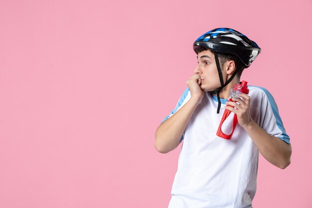 Atleta masculino de vista frontal en ropa deportiva con casco y botella de agua