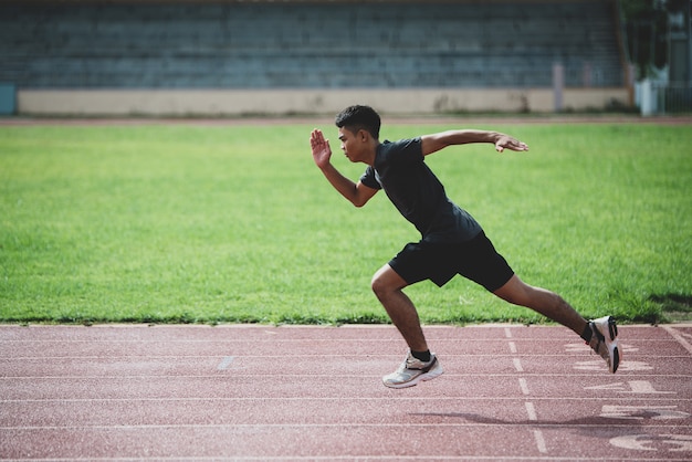 Foto gratuita atleta de pie en una pista de atletismo para todo clima