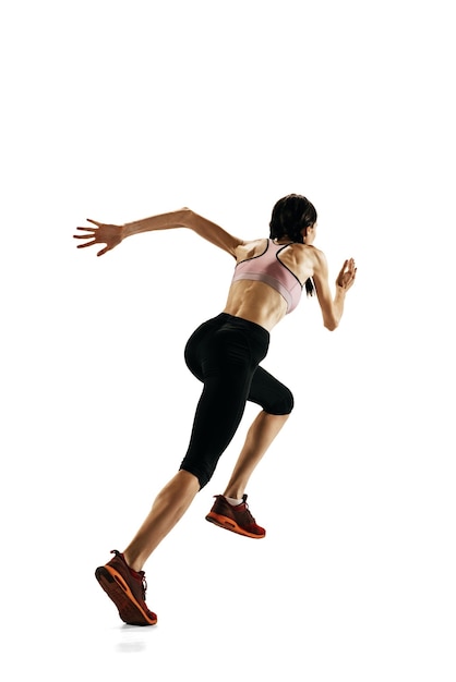 Atleta profesional femenina en entrenamiento uniforme corriendo aislada sobre fondo blanco de estudio