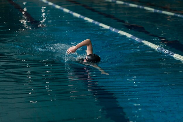Atleta de tiro completo nadando en la piscina