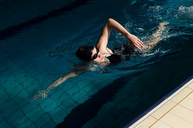 Atleta de tiro completo nadando en la piscina