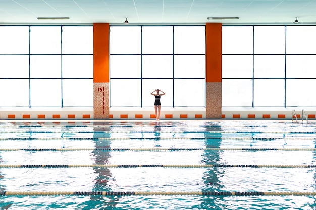 Atleta de tiro largo de pie junto a la piscina