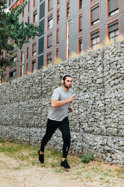 Atleta urbano al lado de muro de piedras