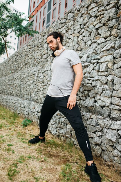 Atleta urbano al lado de muro de piedras