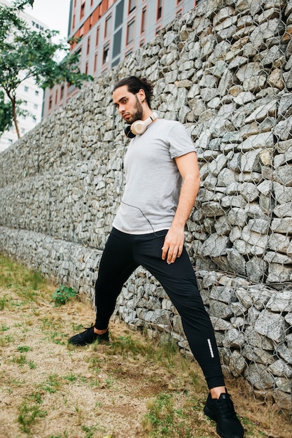 Atleta urbano al lado de muro de piedras