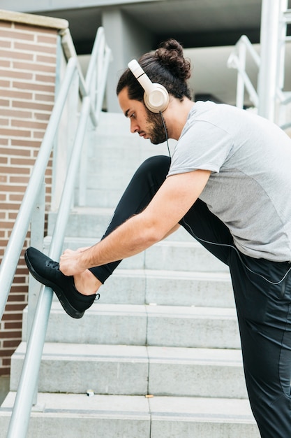 Foto gratuita atleta urbano atando sus zapatos