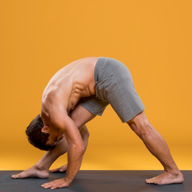 Atlético hombre haciendo yoga pose