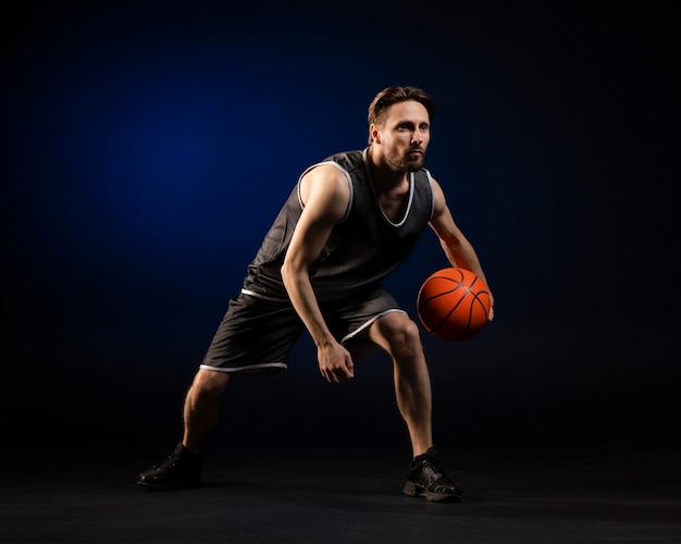 Atlético hombre sosteniendo una pelota de baloncesto