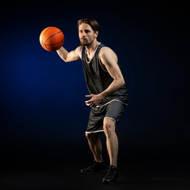 Atlético hombre sosteniendo una pelota de baloncesto