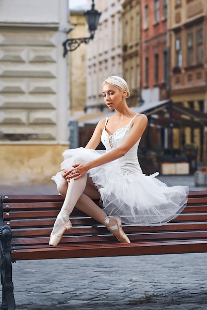 Atractiva bailarina sentada en el banco de la ciudad