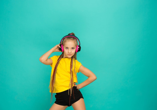 Foto gratuita la atractiva chica con auriculares en pared azul