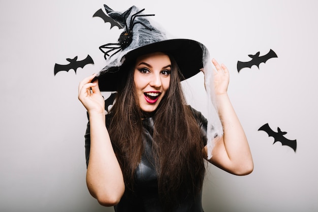 Atractiva chica con sombrero de Halloween en el estudio