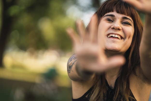 Atractiva joven mujer caucásica con tatuajes haciendo una linda cara