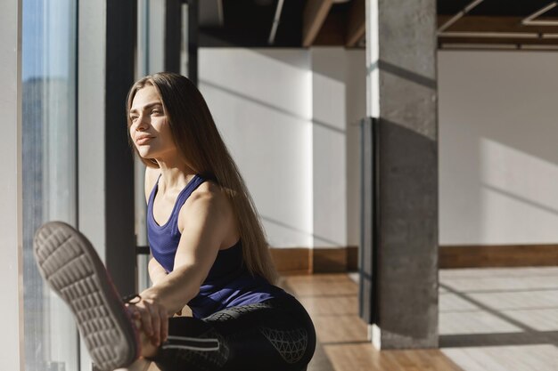 Atractiva joven mujer deportiva y saludable que se extiende sobre la danza ha