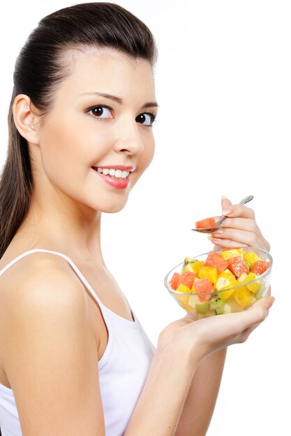 Atractiva joven riendo comiendo fruta postre cítrico