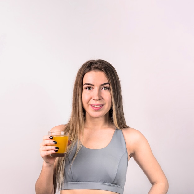 Foto gratuita atractiva joven en ropa deportiva con vaso de jugo.