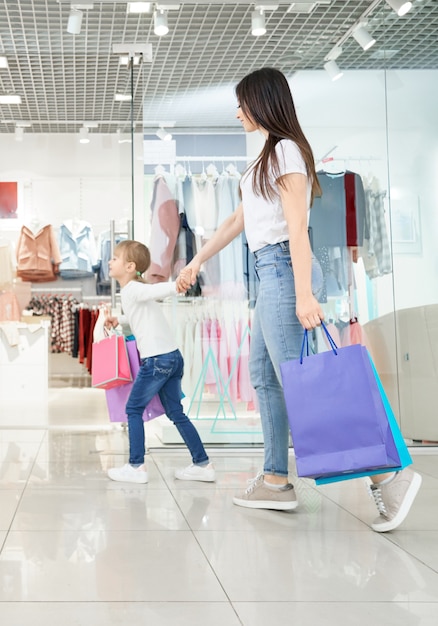 Atractiva madre de compras con pequeña hija en el centro comercial