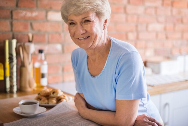 Atractiva mujer adulta en la cocina doméstica